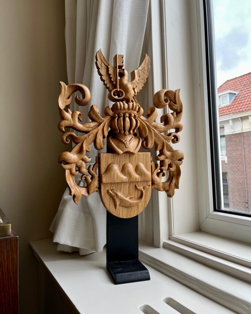 Wooden heraldic coat of arms with eagle and scrollwork on pedestal in window display