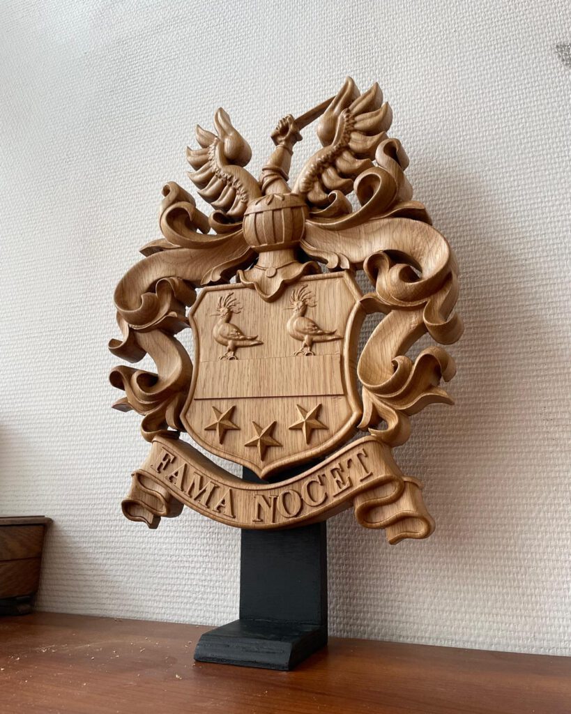 Wooden heraldic coat of arms with dragons and Latin motto on display stand