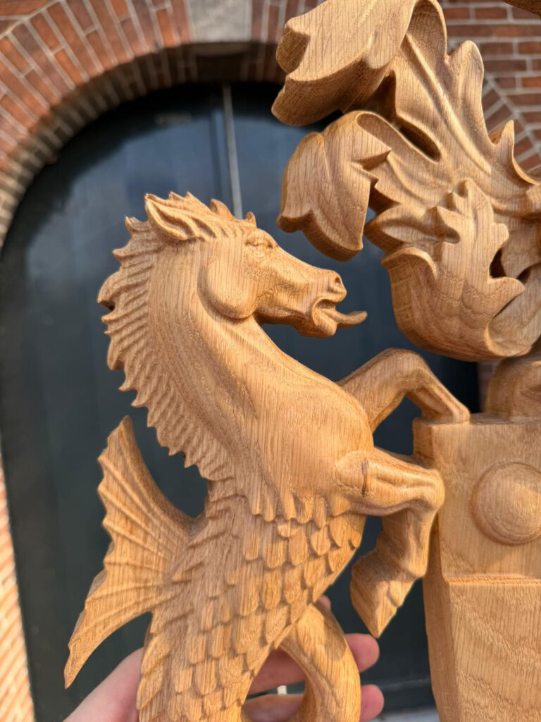 Carved wooden heraldic dragon relief sculpture with detailed wings