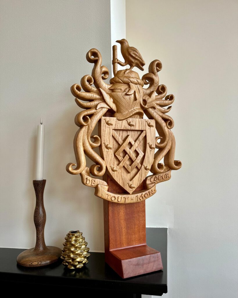 Wooden heraldic coat of arms with eagle sculpture on display stand