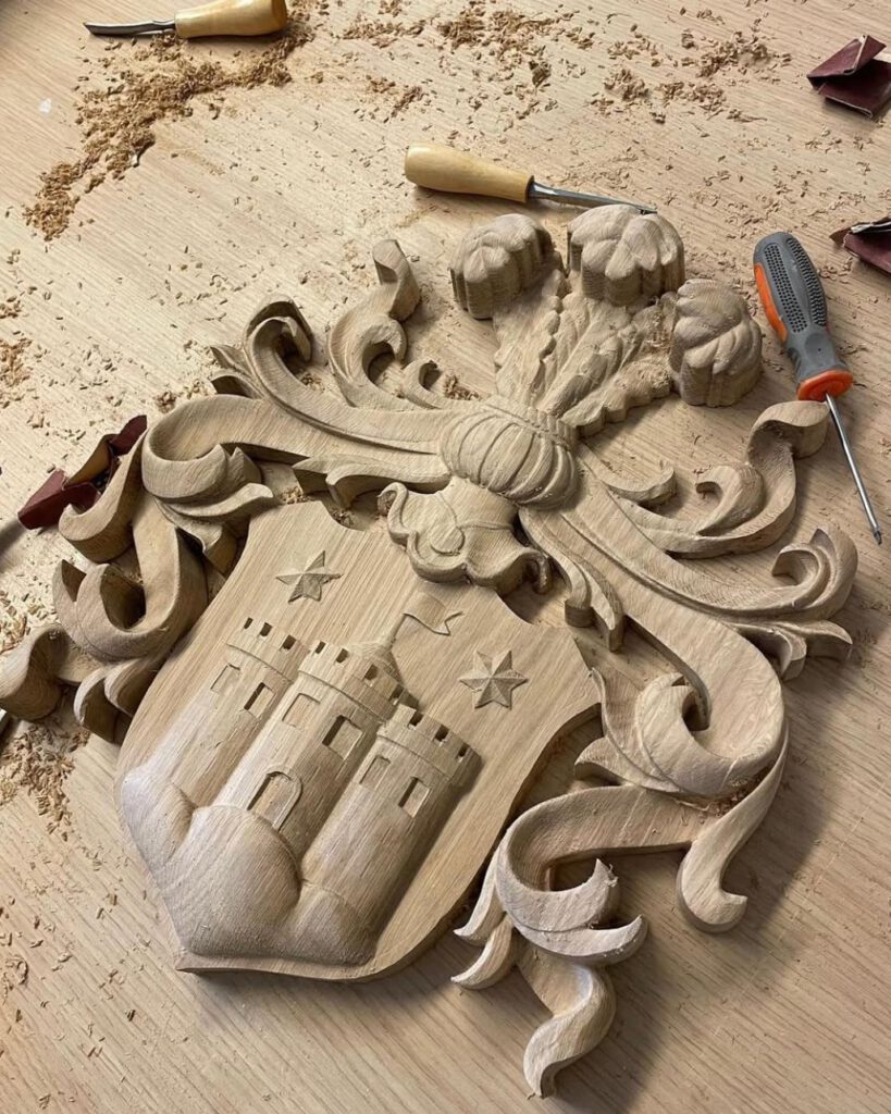 Wooden coat of arms carving with decorative shield in workshop