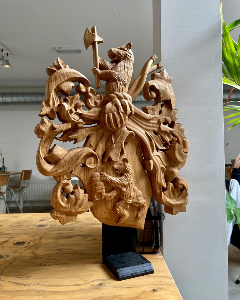 Hand-carved wooden heraldic coat of arms with animal sculptures on display