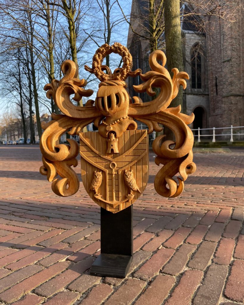 Wooden coat of arms sculpture with decorative flourishes